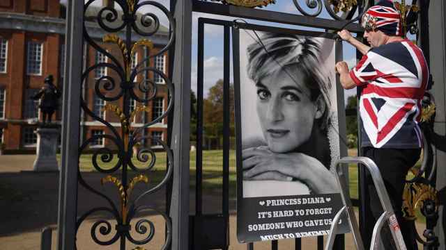 El fan de Diana de Gales John Loughrey coloca un poster en las rejas del Palacio de Kensington en Londres (Reino Unido) - EFE/EPA/TOLGA AKMEN