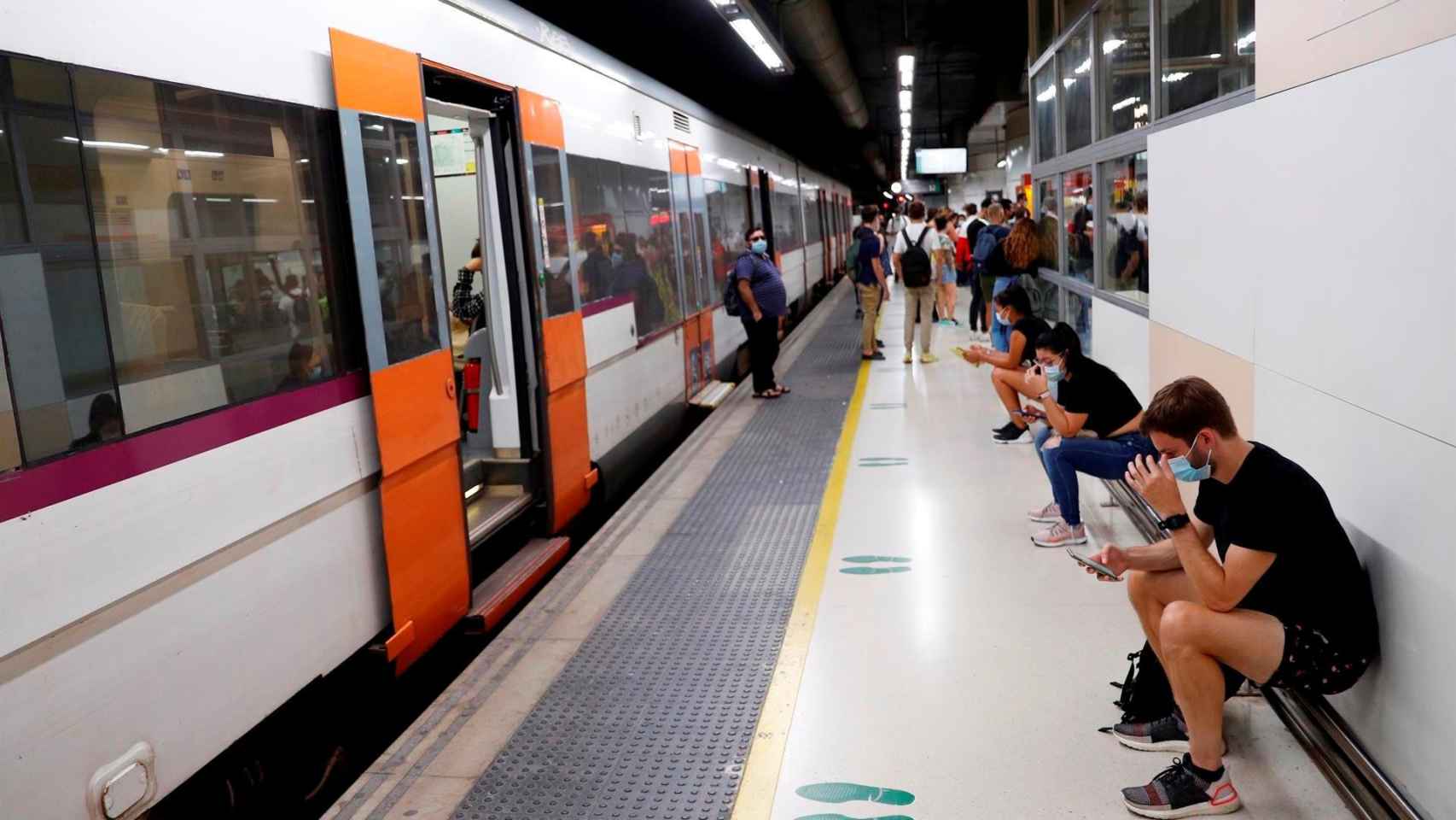 Varios pasajeros esperan ante un tren parado durante la huelga de maquinistas de Renfe en un andén de la estación de Barcelona-Sants / ALEJANDRO GARCÍA - EFE