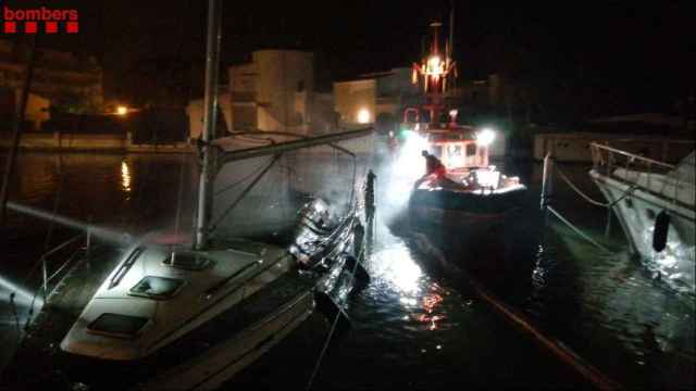 Los bomberos esta noche realizando movimientos de embarcaciones junto a las dos barcas incendiadas en Roses (Girona) / BOMBERS