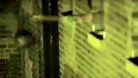 Un dron acerca una bolsa negra a la ventana de una cárcel de Londres mientras un preso la recoge con un palo.