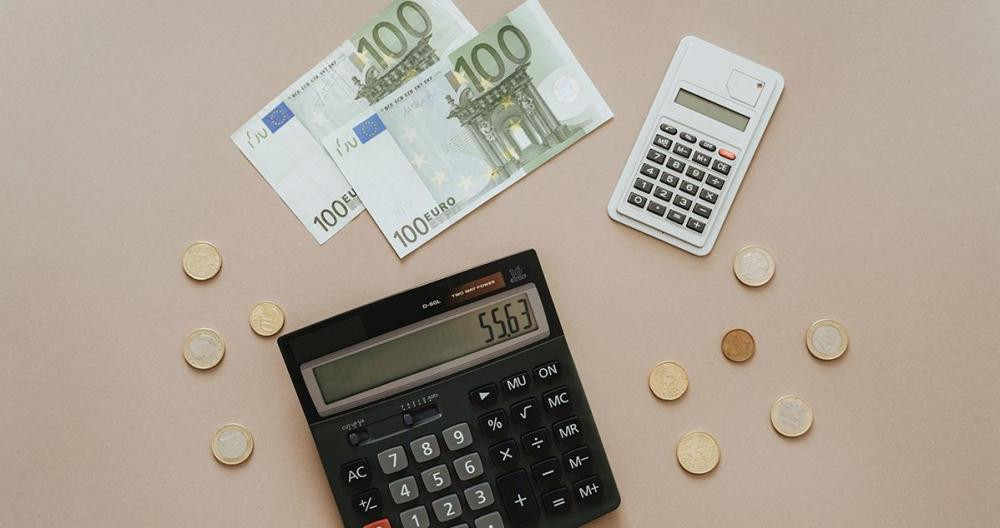 Una calculadora y euros en billete y moneda / PEXELS