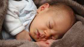 Un bebé recién nacido duerme sobre una manta / CG