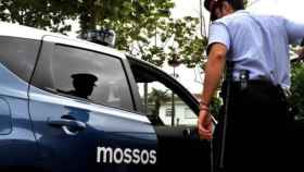 Un agente de los Mossos junto a un vehículo policial / EP