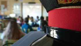 Una gorra de Mossos d'Esquadra en un aula con estudiantes para ilustrar la conciliación / MOSSOS