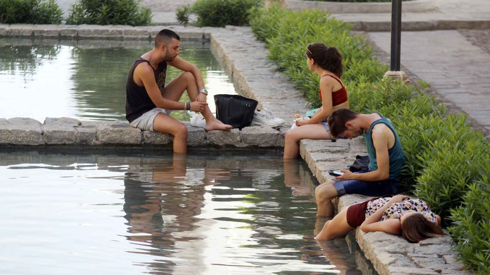 Unos jóvenes se refrescan en una fuente en Córdoba durante la ola de calor de mediados de junio / EFE
