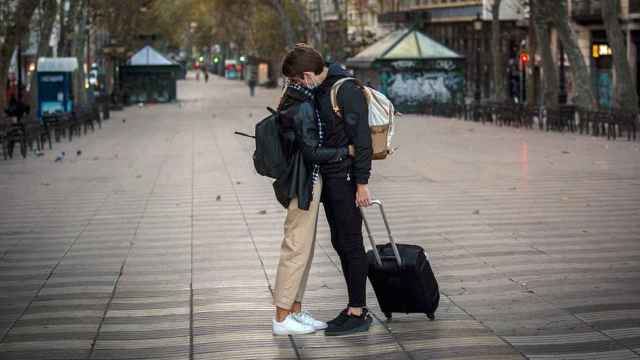 Dos turistas se despiden en unas Ramblas de Barcelona, Cataluña, totalmente desiertas / EUROPA PRESS