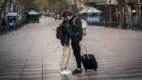 Dos turistas se despiden en unas Ramblas de Barcelona, Cataluña, totalmente desiertas / EUROPA PRESS