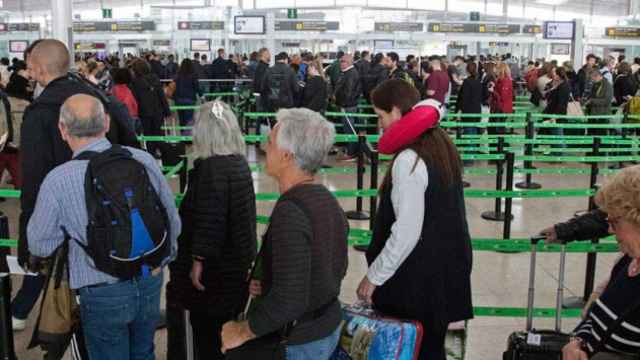Largas colas en el aeropuerto de El Prat para pasar los controles de seguridad este viernes / CG