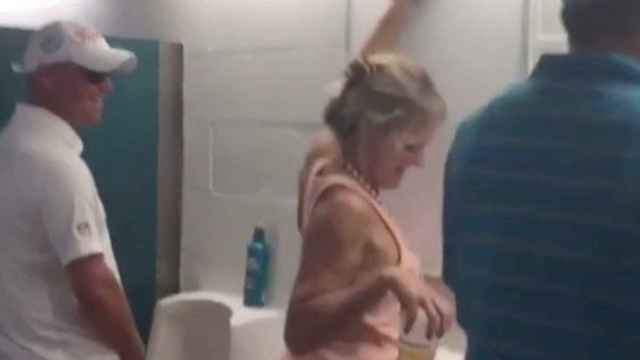 La mujer mientras orina en el baño de hombres