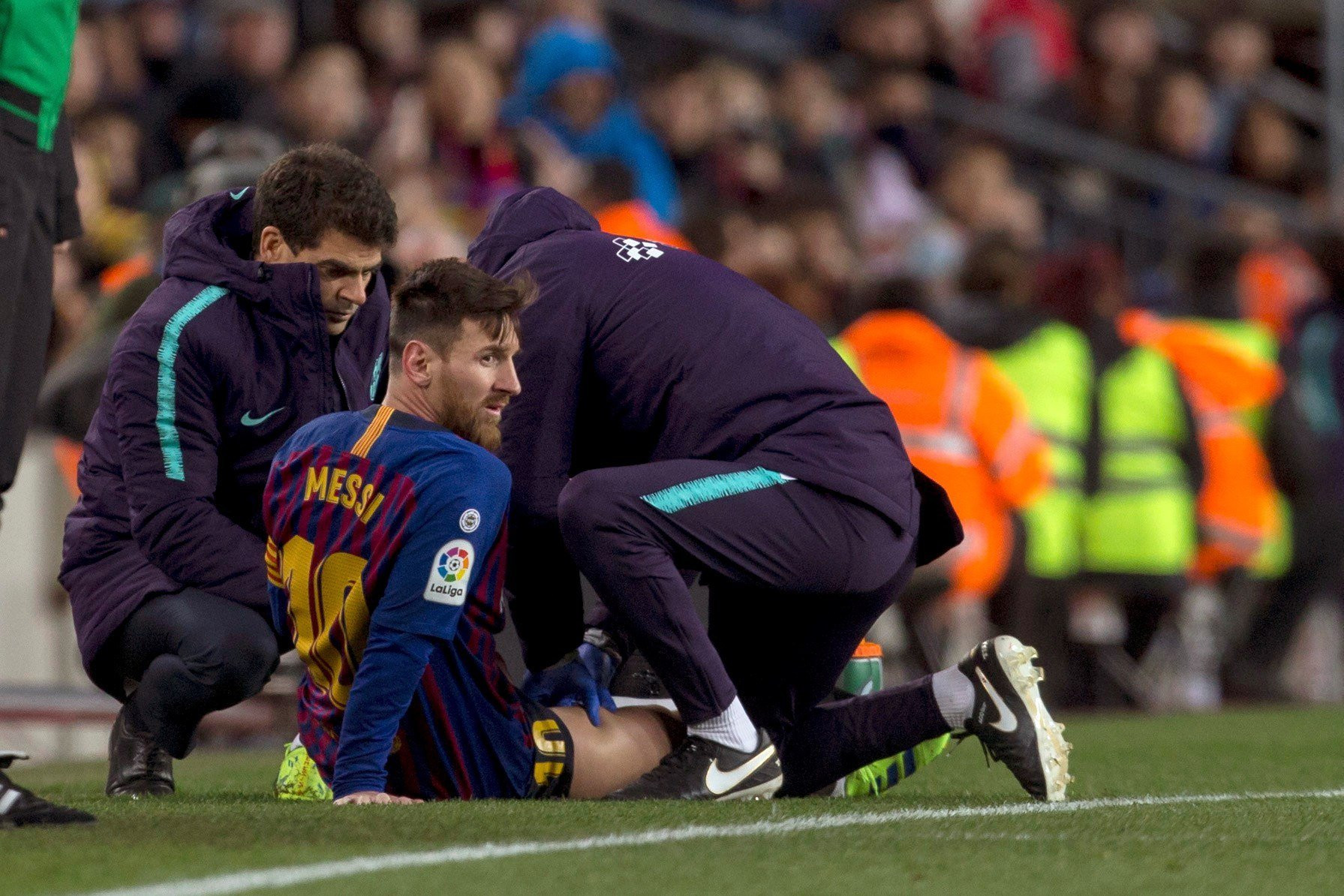 Messi es atendido en la banda durante el Barça-Valencia / EFE