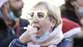 Una mujer se come las uvas durante la celebración del simulacro de las preuvas en la Puerta del Sol de Madrid / Eduardo Parra (EP)