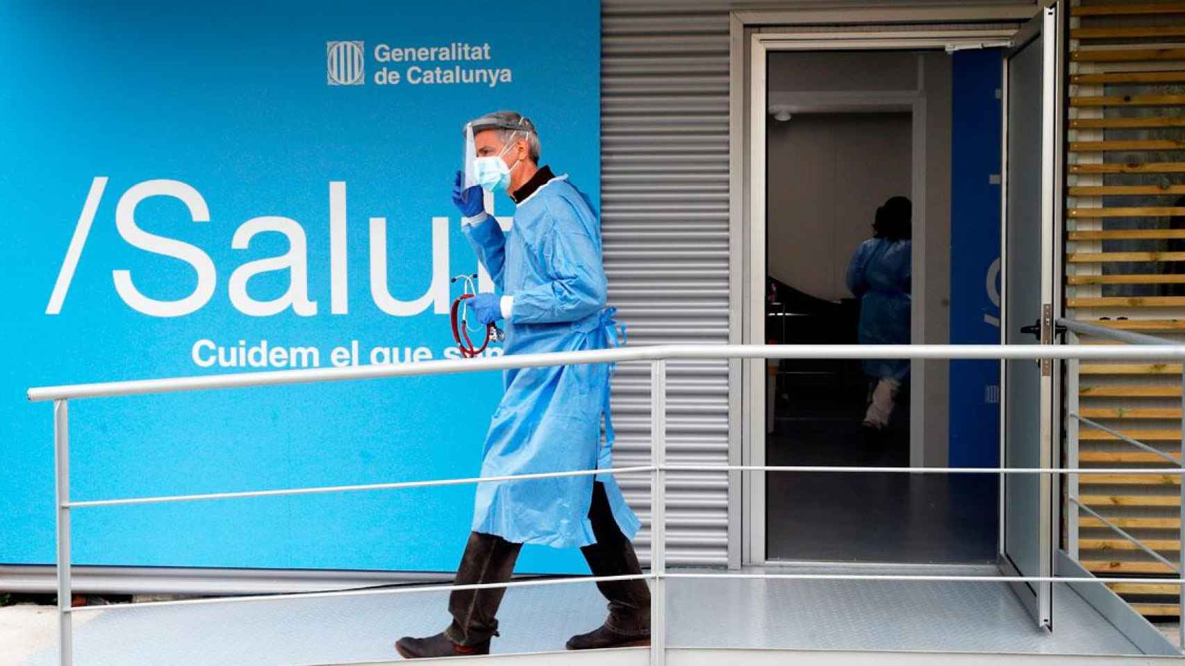 Un sanitario, saliendo de un módulo instalado por Salud en un ambulatorio catalán, que ahora lleva el peso de la vacunación / EFE