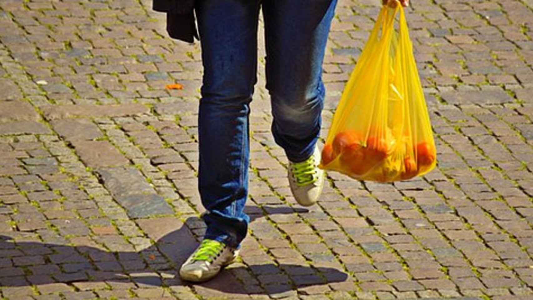 Una persona camina por la calle con una bolsa de plástico / PIXABAY