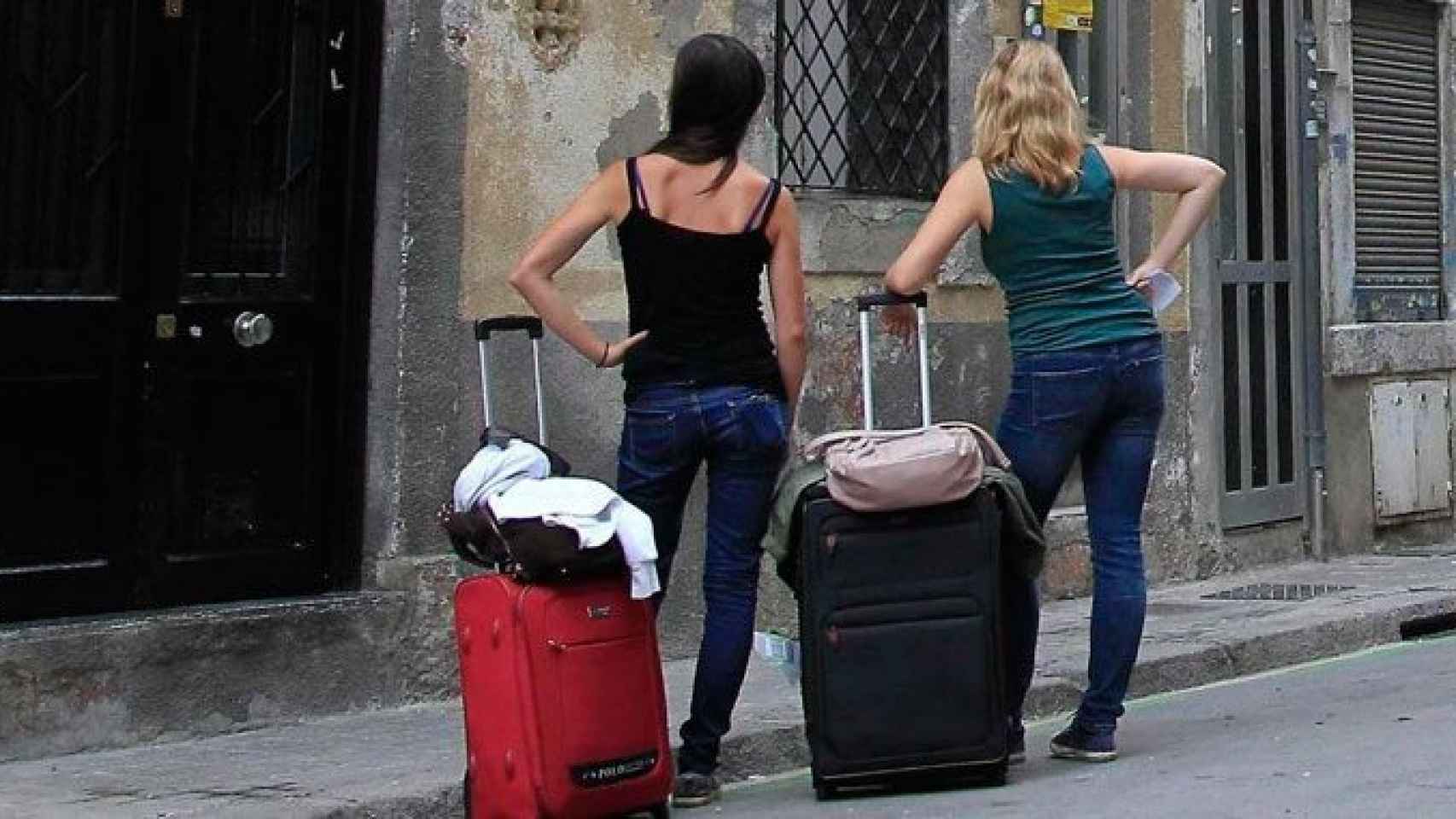 Dos turistas esperan en la puerta de un piso turístico en Barcelona / EFE