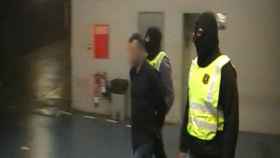 El presunto yihadista detenido este jueves en Barcelona, custodiado por dos Mossos.