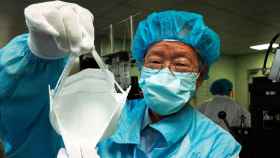 Imagen de un sanitario colocando una máscara quirúrgica para proteger contra el virus que causa la neumonía de Wuhan / EFE