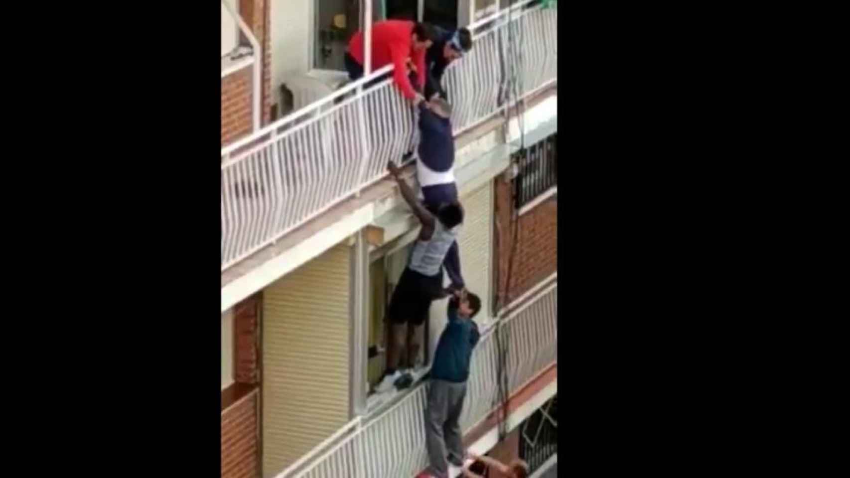 Unos vecinos ayudan a un hombre a punto de caer de un balcón / EP