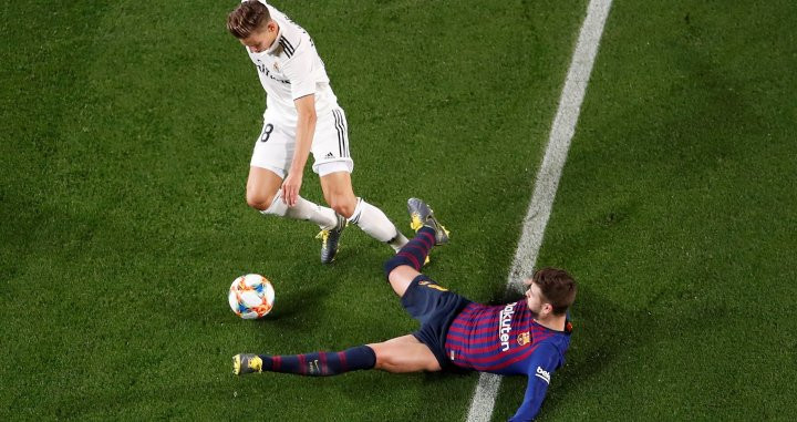 Gerard Piqué disputa un balón con el futbolista del Real Madrid Marcos Llorente