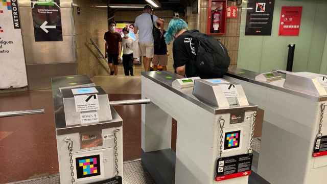 Máquinas validadoras del metro con el mensaje manuscrito que indica que solo se acepta la T-Mobilitat / CG