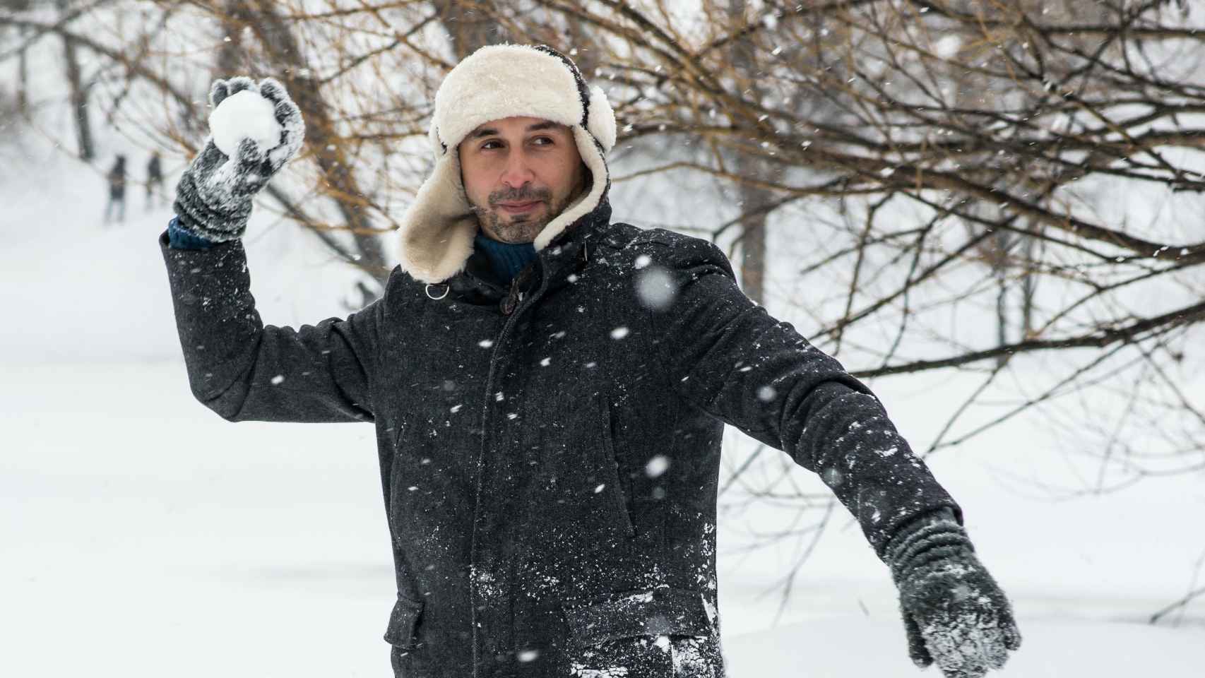 Un chico con un buen abrigo tirando una bola de nieve / PEXELS