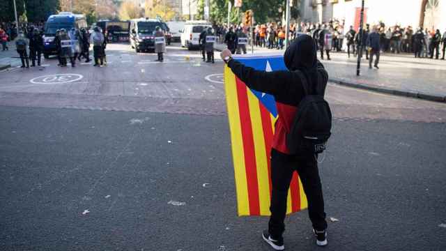 Un manifestante porta la bandera independentista y se la enseña a la policía durante la concentración en contra del Consejo de Ministros del 21 de diciembre del 2018 / EP