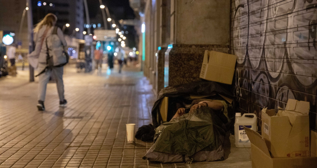 Una persona sin hogar duerme en una calle de Barcelona / KIKE RINCÓN - EUROPA PRESS
