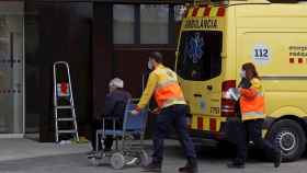 Dos técnicos de emergencias trasladan a un paciente al hospital satélite del Hospital Universitario de Bellvitge / ALEJANDRO GARCÍA - EFE