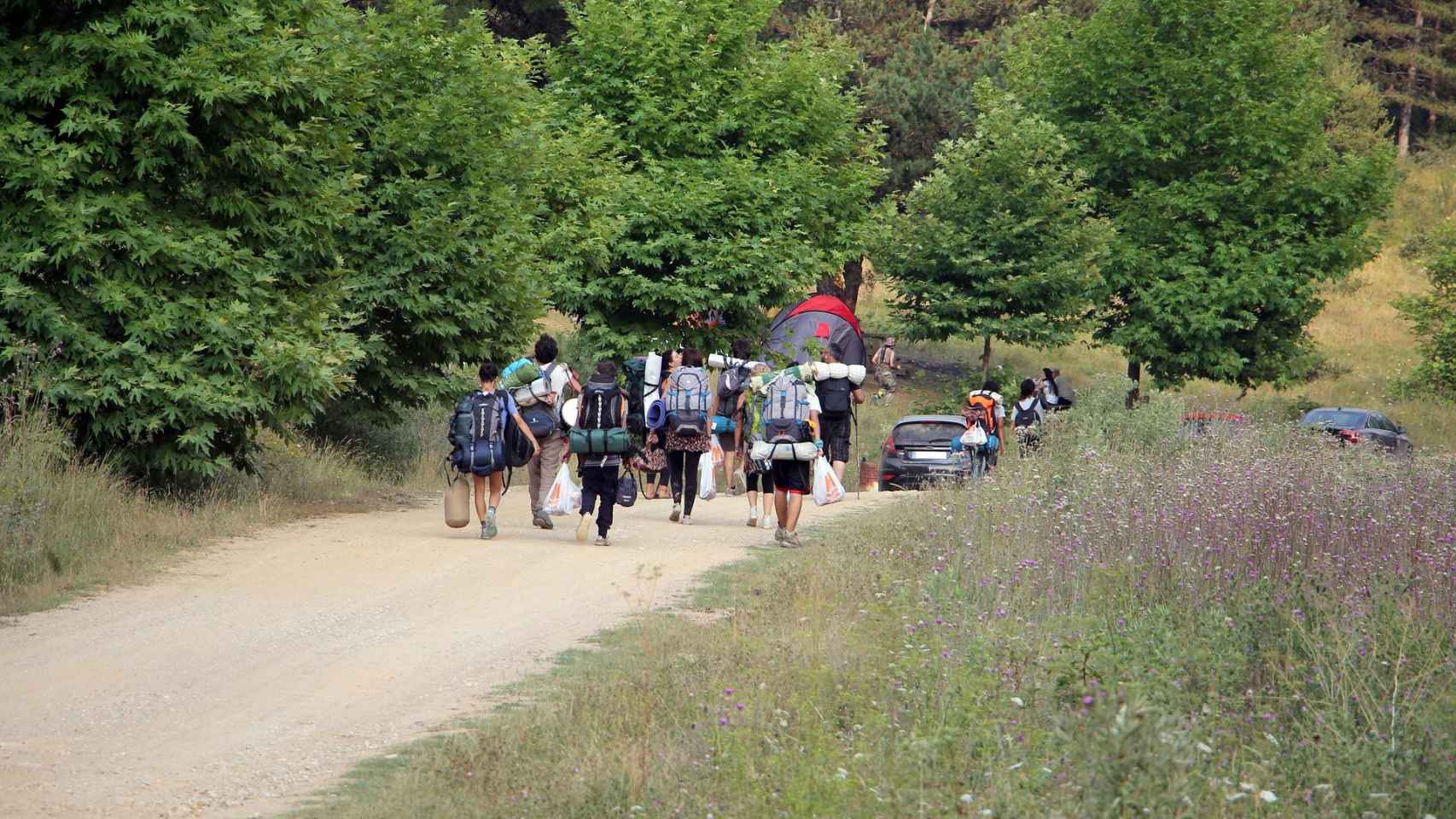 Miembros de un campamento de verano abandonan la zona equipados con sus pertenencias / CG