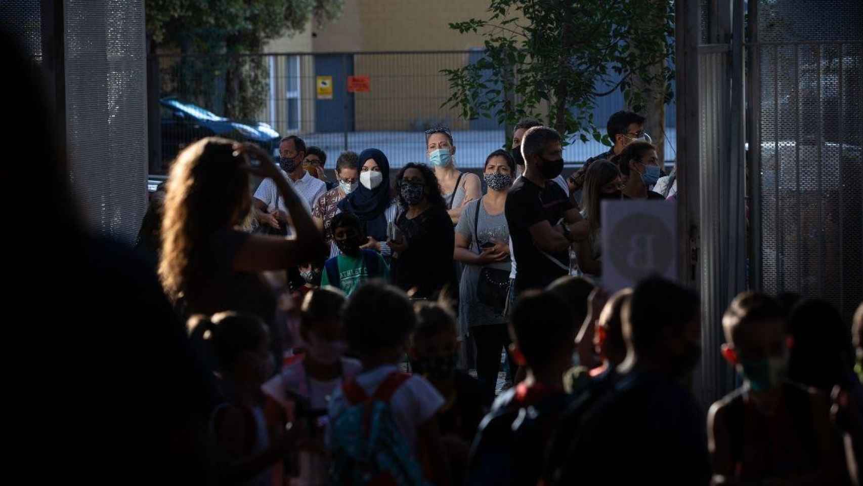 Padres y alumnos esperan a las puertas de un colegio en Cataluña, donde el nuevo curso escolar arranca este lunes / David Zorrakino (EP)