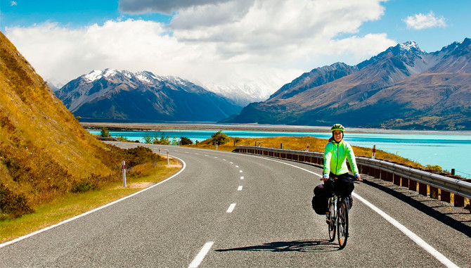 Una chica en bicicleta entre paisajes de Nueva Zelanda