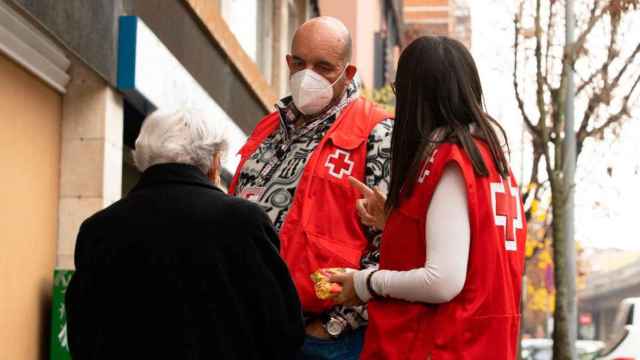 Dos trabajadores de Cruz Roja, atendiendo a una ciudadana de avanzada edad / Cedida
