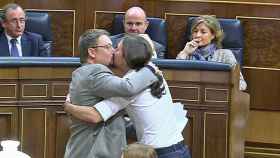 Pablo Iglesias y Xavier Domènech se abrazan y besan tras la intervención del primero de ellos en la tribuna del Congreso ante la mirada atónita de los diputados del PP.