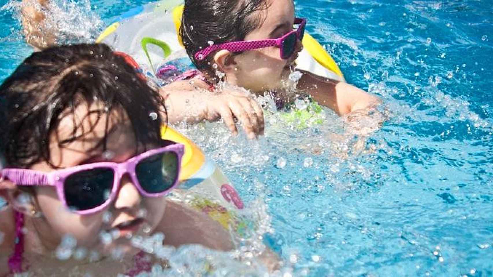 Dos niñas se bañan en una piscina municipal