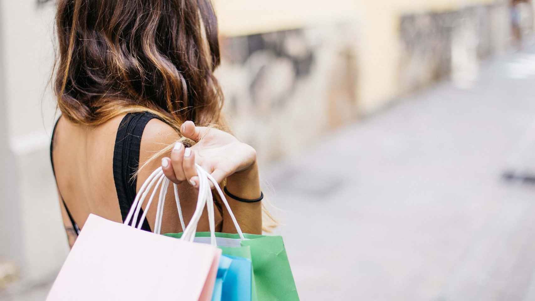 Una mujer sujeta bolsas después de comprar en centros comerciales / PIXABAY