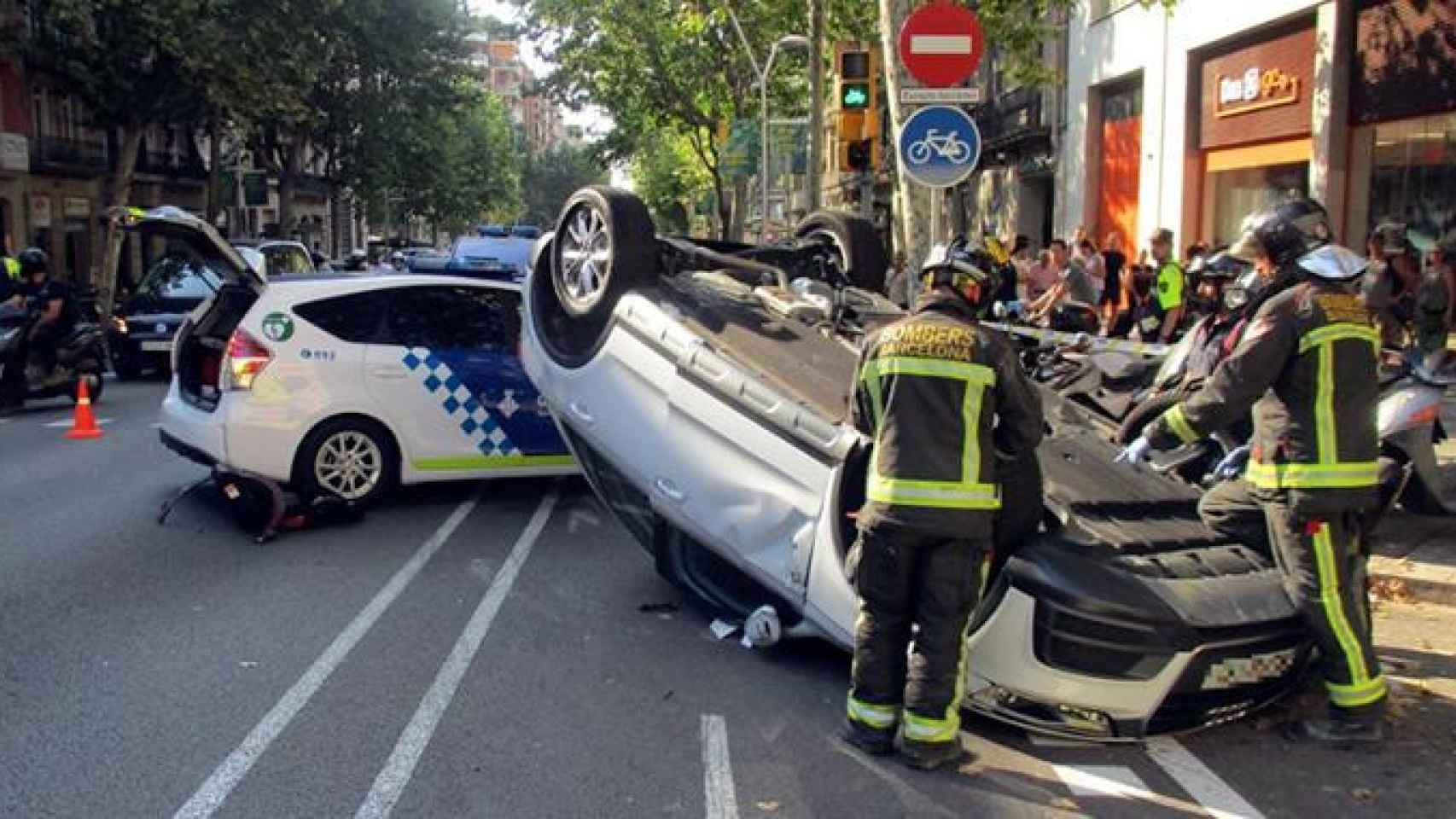 Un coche ha volcado en el Eixample de Barcelona, en el cruce entre las calles Urgell y Diputació / GUARDIA URBANA
