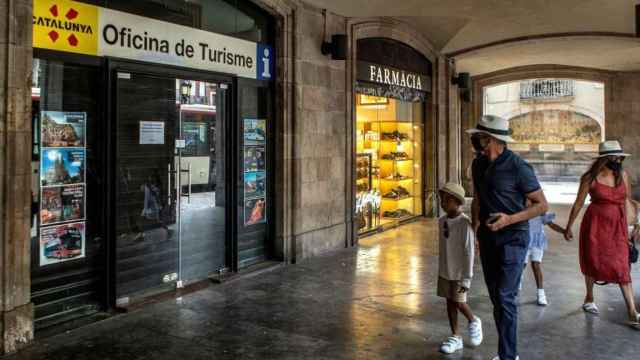 Una familia de visitantes, ante una oficina de turismo cerrada en el centro de Barcelona / EFE