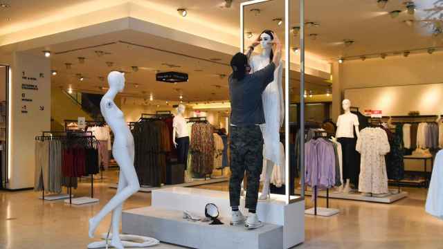 Un trabajador de Inditex cambia el escaparate de una tienda de Zara / EP