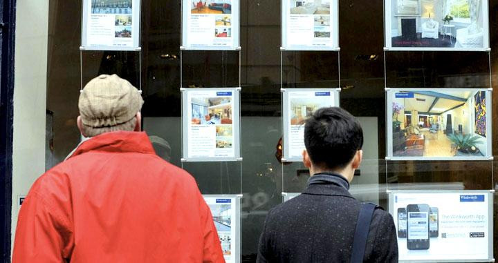 Dos clientes miran viviendas en una inmobiliaria / EFE