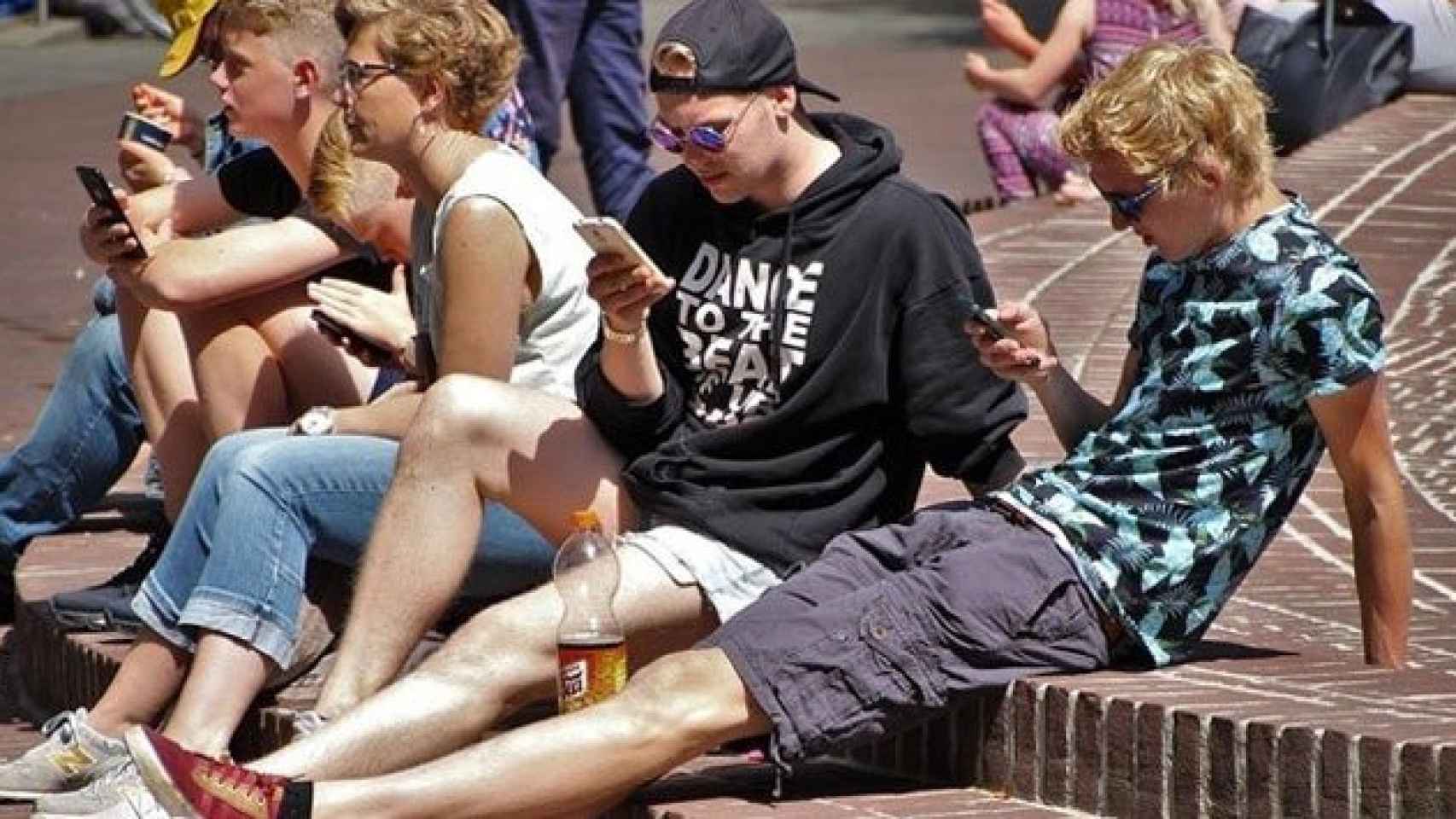 Jóvenes navegan con sus móviles en las redes sociales
