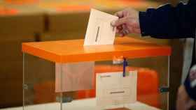 Un votante deposita una papeleta electoral en una urna para escoger senadores.