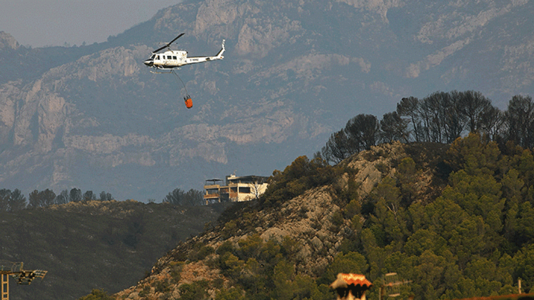 Un helicóptero participa en las labores de extinción del incendio declarado el lunes en Llutxent / EFE
