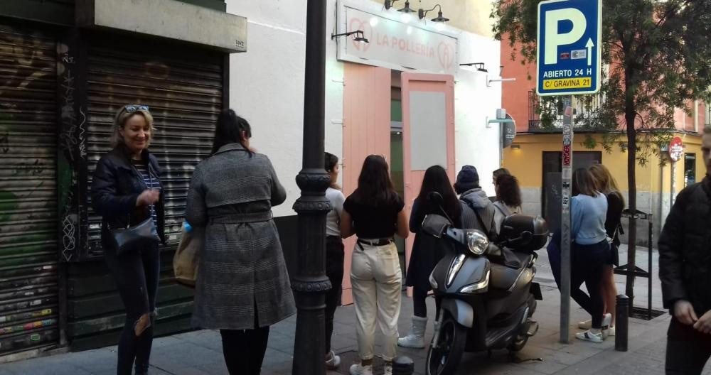Una fila de personas espera a que abra La Pollería, en Madrid / L. M. G.