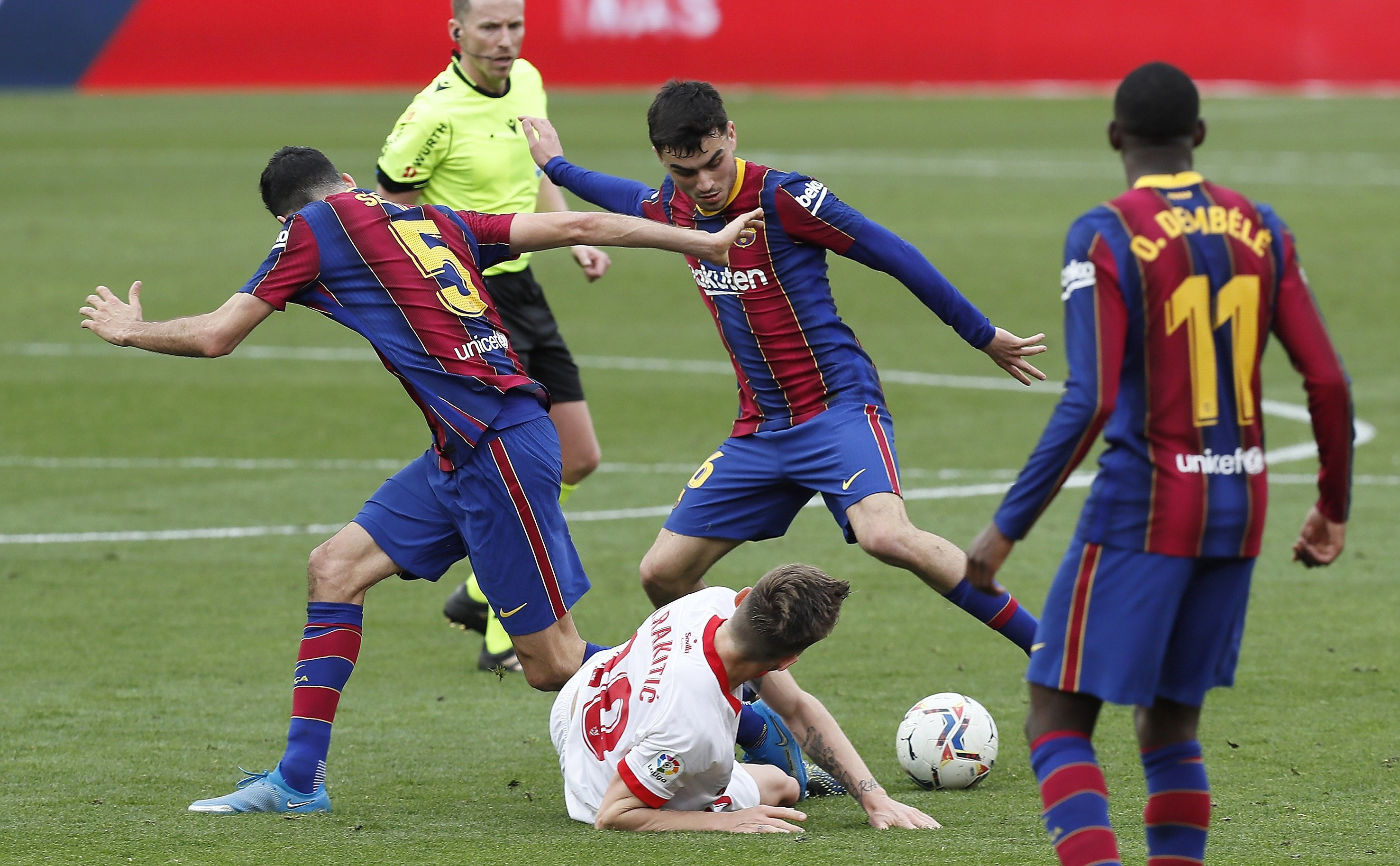 Pedri y Sergio Busquets luchando un balón contra el Sevilla / EFE
