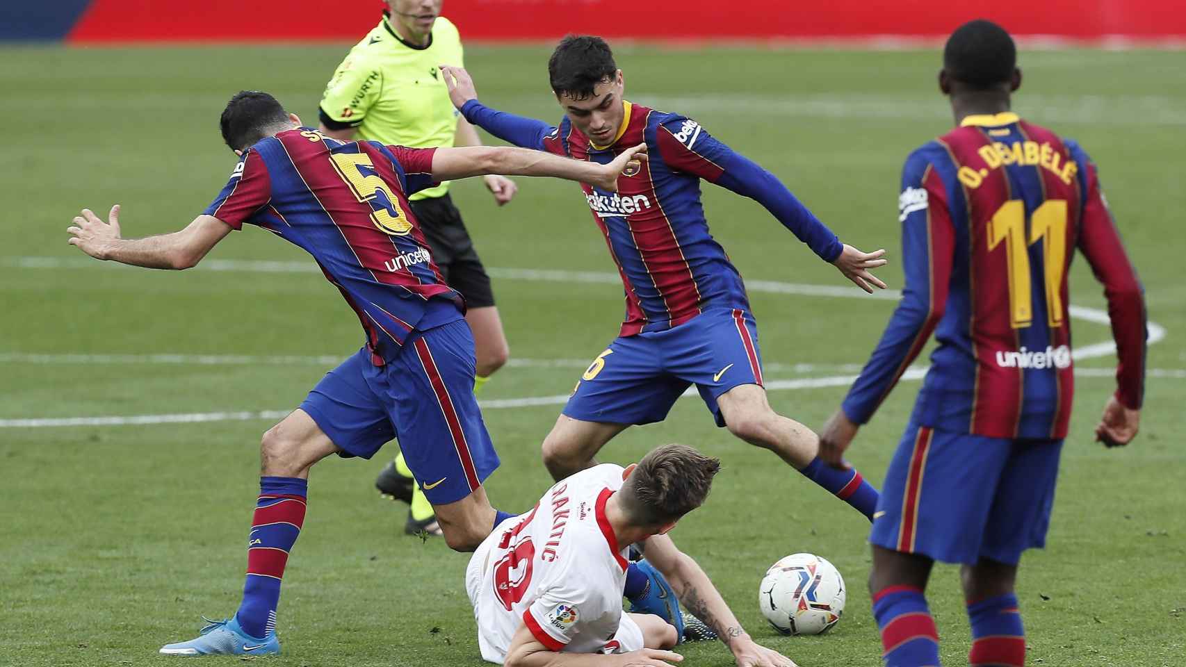 Pedri y Sergio Busquets luchando un balón contra el Sevilla / EFE