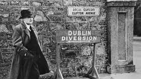 Flann O Brien, delante del cartel de los 'Dublin Diversion'