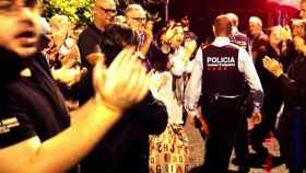 Una pareja de Mossos d'Esquadra salen entre aplausos de una escuela del barrio de Sarriá de Barcelona / EFE