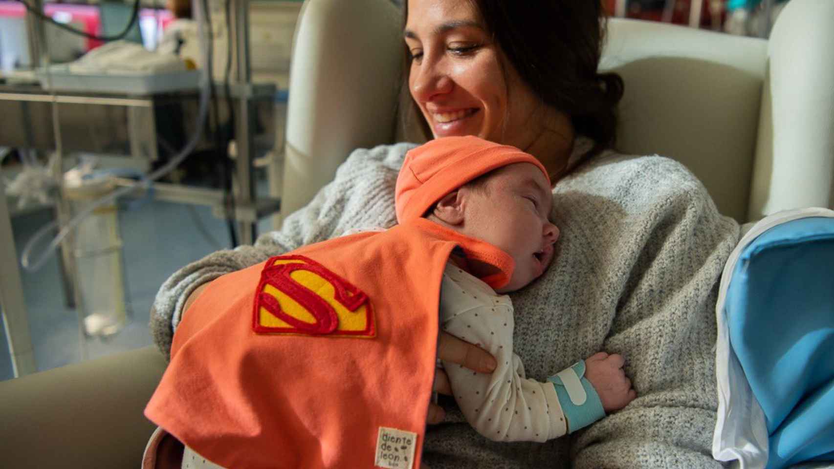 Un neonato, disfrazado de superhéreo, junto a su madre en el Hospital Clínic / CLÍNIC