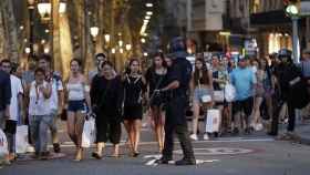 Un grupo de gente se desplaza esta noche entre el despliegue policial en el lugar del atentado ocurrido en las Ramblas de Barcelona / EFE