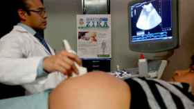 Un médico practica una ecografía a una mujer embarazada.