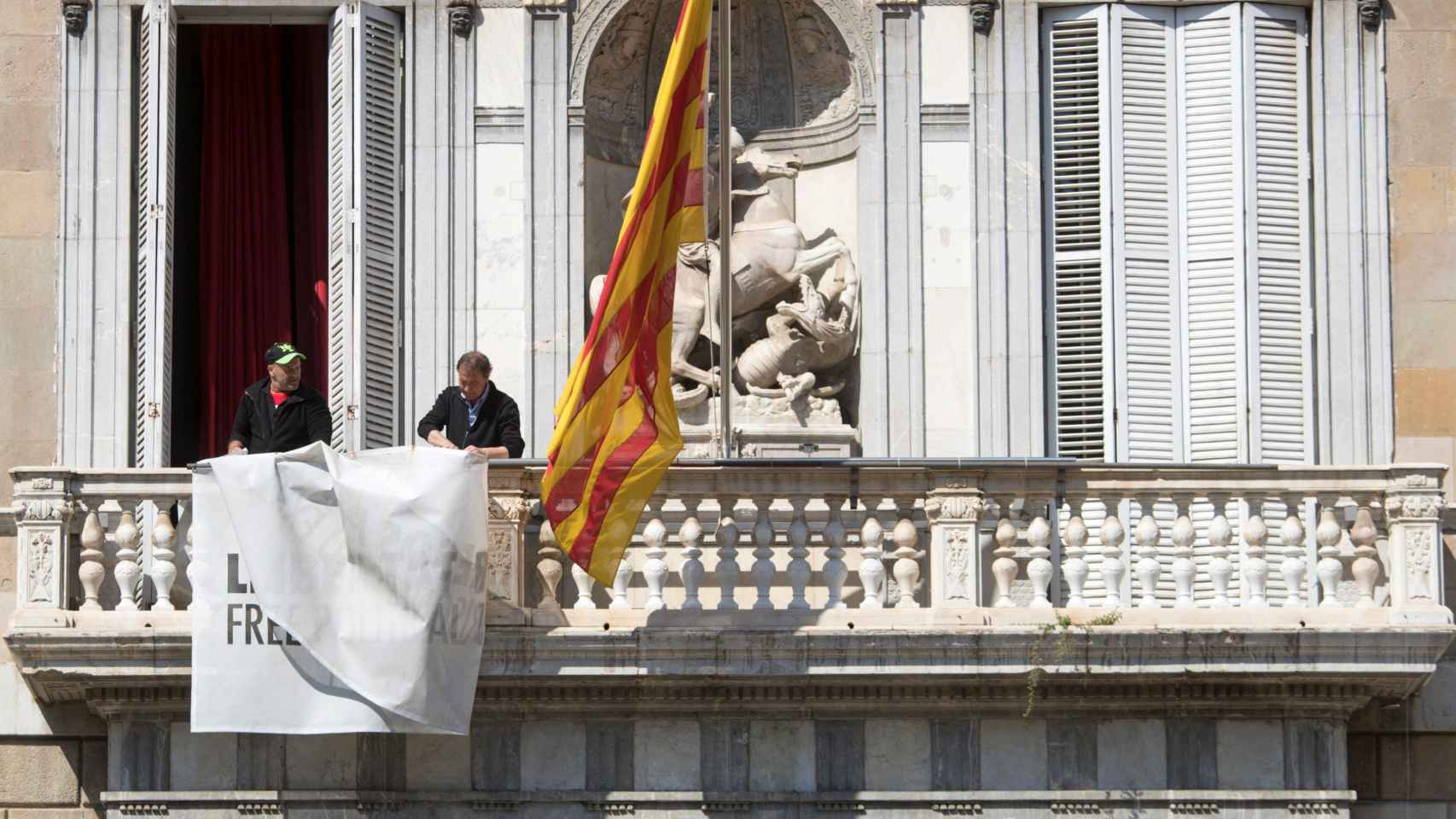 Dos operarios retiran la simbología independentista del Palau de la Generalitat. Emocionales / EFE